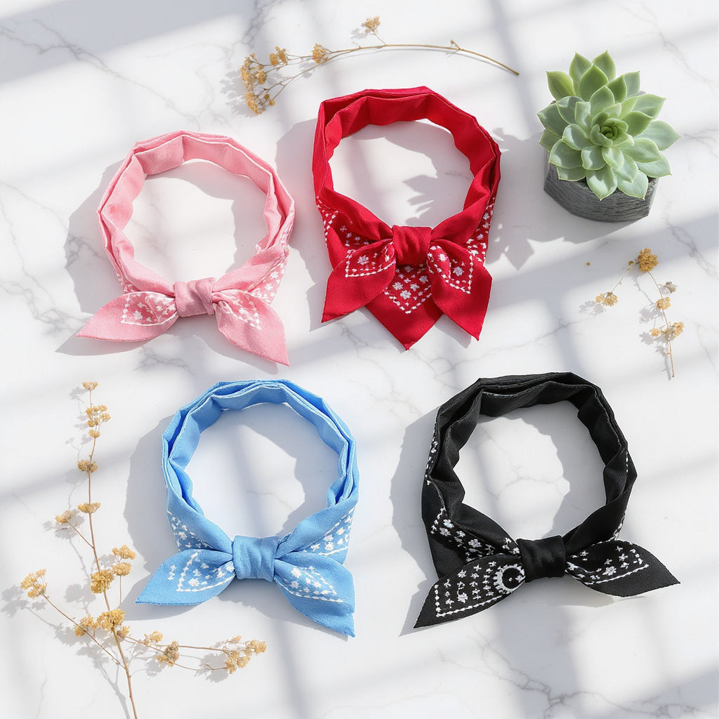 Aesthetic flat lay of four pet bandana collars on white marble